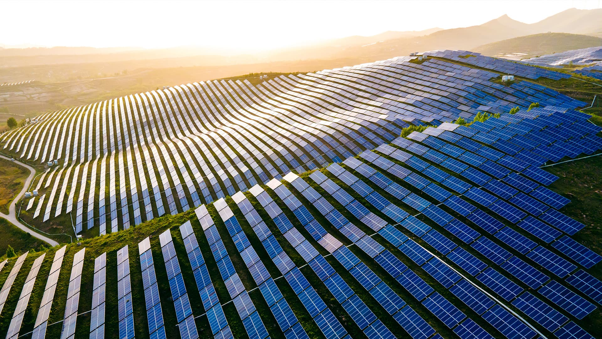 Aerial view of a solar farm along a mountain