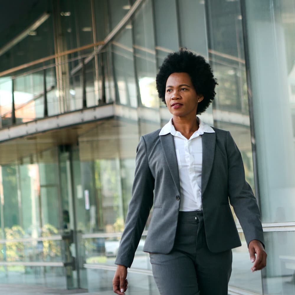 Corporate woman walking by buildings